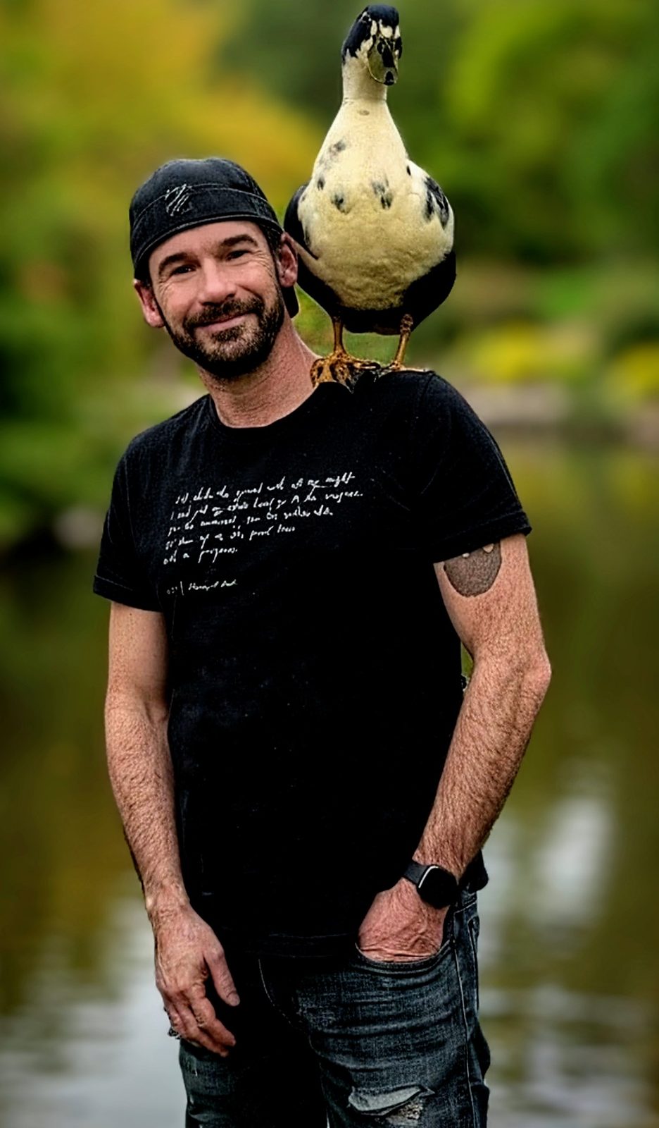 Cap standing by the pond with Biskit perched on his shoulder